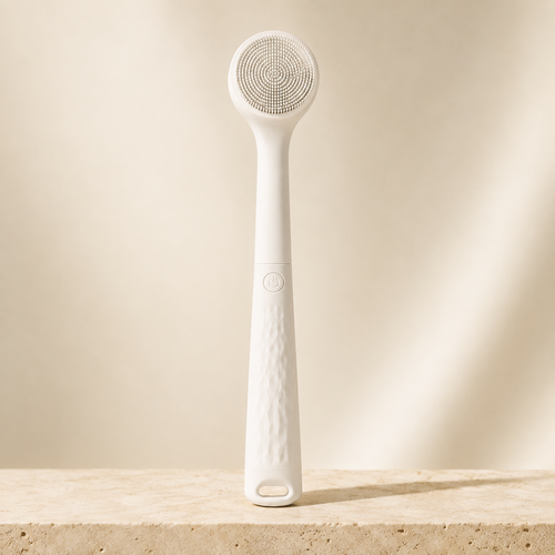 White Bristlewell electric body brush standing upright against a plain warm backdrop