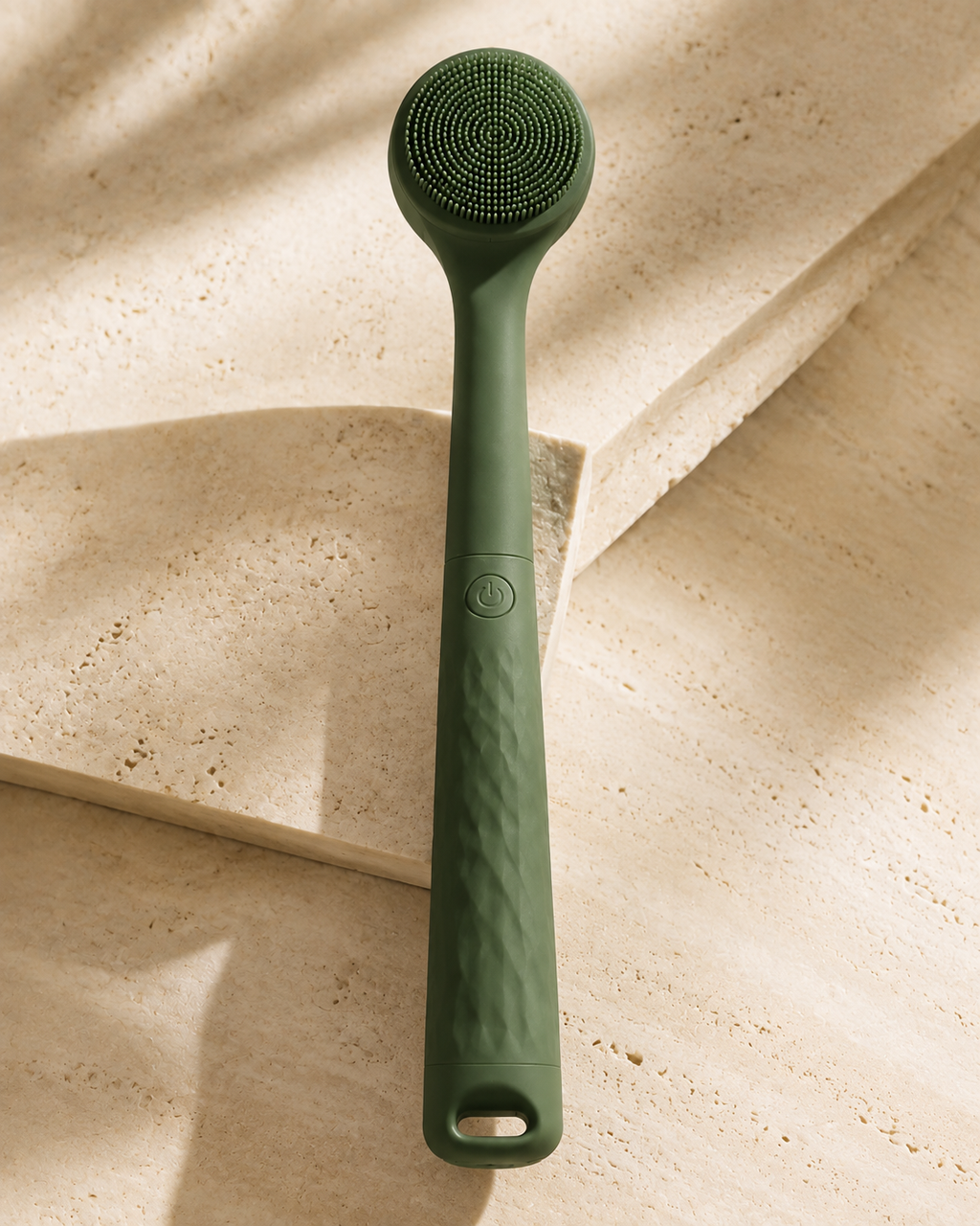 Close-up of the Bristlewell handle showing the power button and textured grip